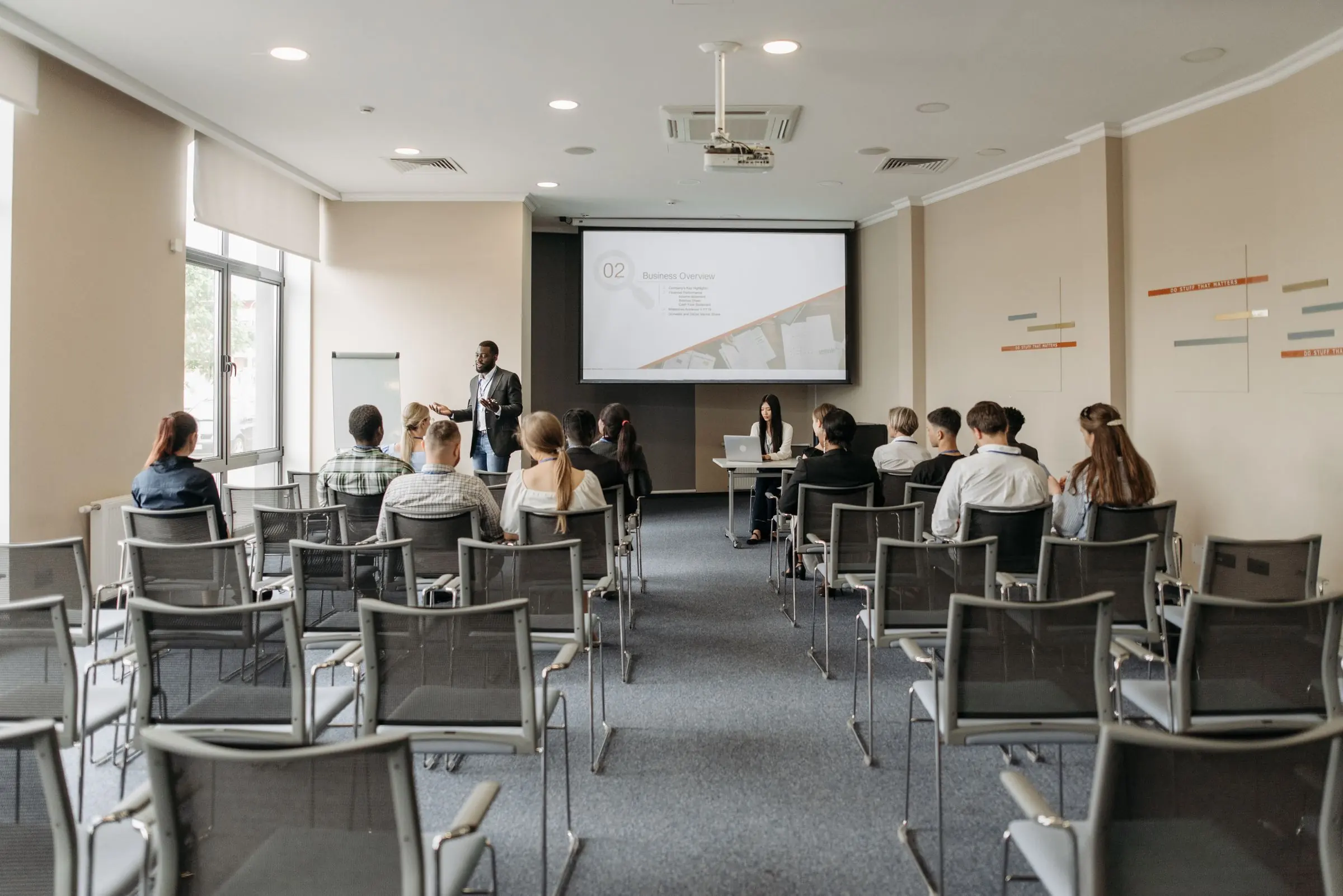 Teilnehmende im Theorieraum vor einer Leinwand