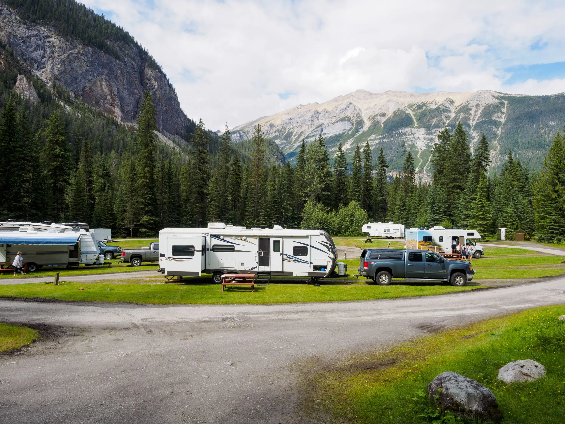 Autos mit Wohnwagen auf einem Campingplatz in den Bergen